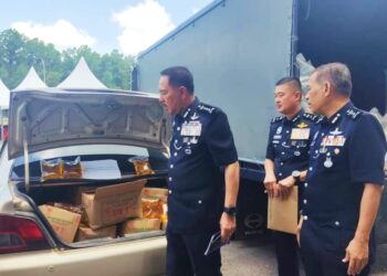 MUHAMAD Zaki Harun (tiga kanan) memeriksa minyak masak bersubsidi yang dirampas di Kampung Haji Wan Omar Cherang Ruku, Pasir Puteh, Kelantan semalam-UTUSAN/ROHANA ISMAIL