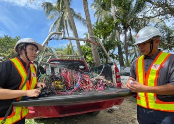 ADDIE Ahmad (kanan) menunjukkan wayar yang digunakan untuk penyambungan haram di Kampung Numbak, Kota Kinabalu hari ini.