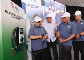 ALEXANDER Nanta Linggi (kiri) melihat replika pengecasan kereta elektrik pada Majlis Perasmian Kemudahan Pengecasan Berkelajuan Tinggi TNB Electron di Hentian Rehat dan Rawat Ayer Keroh Arah Utara, Melaka. - UTUSAN/MUHAMMAD SHAHIZAM TAZALI