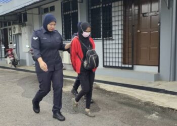 FATIMAHTONZURA Hassan (tengah) dibawa ke Mahkamah Majistret Kuala Pilah bagi dituduh kerana dituduh membuat laporan polis palsu kononnya disamun dalam kejadian pada bulan Disember tahun lalu.-UTUSAN/NOR AINNA HAMZAH.