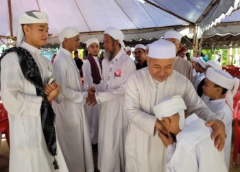 TUAN Ibrahim Tuan Man (dua dari kanan) sempat beramah mesra dengan pelajar-pelajar tahfiz ketika tiba di Majlis Perasmian Bangunan Asrama Tahfiz Al-Quran Al-Ikhwan di Kampung Kota, Kota Bharu, Kelantan hari ini. UTUSAN/MUSTAQIM MOHAMED