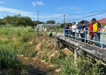 LIM BAN Hong bersama penduduk Taman Bukit Rambai, Melaka meninjau Sungai Lereh yang tercemar bertukar hitam dan berbau busuk. - UTUSAN/AMRAN MULUP