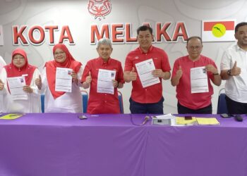ABDUL RAZAK Abdul Rahman (lima dari kiri) bersama jawatankuasa yang lain menunjukkan borang pencalonan di Pejabat UMNO Bahagian Kota Melaka, Ayer Leleh, Melaka. - UTUSAN/AMRAN MULUP