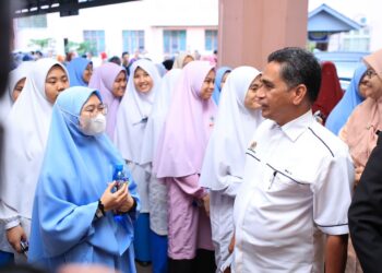 MOHD. Zin Halim (kanan) menitipkan pesanan kepada kepada Calon SPM sebelum melangkah masuk ke dewan peperiksaan di SMKA Naim Lilbanat, Kota Bharu, Kelantan.UTUSAN/KAMARUL BISMI KAMARUZAMAN.