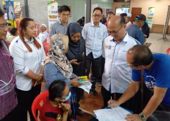 NORENA Jaafar (lima dari kanan) melihat peniaga mendaftar bagi perkhidmatan e-wallet selepas Taklimat ReDI di Kompleks Japerun Machap Jaya, Alor Gajah, Melaka. - UTUSAN/AMRAN MULUP
