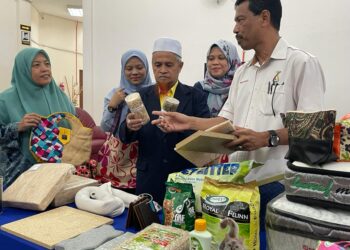 KAMERUZAMAN Yusof (tengah) melihat hasil kenaf yang boleh dipelbagaikan produk hiliran di Pasir Puteh, Kelantan, hari ini.UTUSAN/TOREK SULONG