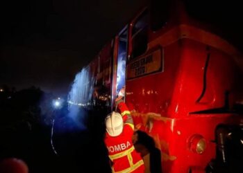 ANGGOTA Bomba dan Penyelamat berusaha memadamkan kebakaran melibatkan kepala kereta api yang terbakar di dekat Tasek Taman Kiara, Tanah Merah, Kelantan malam tadi.-UTUSAN/IHSAN JBPM