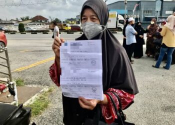 NIK Dah Yusoff menunjukkan surat bayaran penuh untuk menunaikan umrah di Kota Bharu Kelantan hari ini.- UTUSAN/ROSLIZA MOHAMED