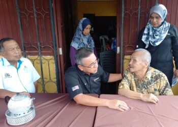 ADLY Zahari berbual dengan seorang veteran ATM, Zamri Kasmin yang mengalami masalah penglihatan di Kampung Sungai Petai, Alor Gajah, Melaka. - UTUSAN/AMRAN MULUP
