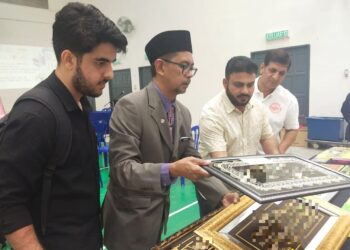 AHMAD Husaini Mustafa (dua dari kiri) menunjukkan perhiasan ayat al-Quran yang mengandungi kesalahan ayat pada Program Program Advokasi Peniaga-Peniaga dan Pengusaha Bingkai Ayat Al-Quran Di Ibu Pejabat Polis Daerah Nilai di Seremban hari ini.-UTUSAN/NOR SHAFAWATI YUP.