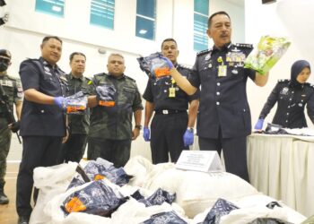 Muhammad Zaki Harun (kanan) menunjukkan dadah jenis syabu yang di rampas Batalion 9 PGA selepas sidang media di IPD Pasir Mas, Kelantan hari ini.-UTUSAN/ROHANA ISMAIL.