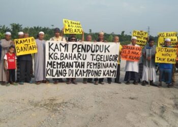 PENDUDUK Kampung Baharu, Tasek Gelugor, Pulau Pinang mengadakan bantahan aman di tapak yang dicadangkan untuk pembinaan kilang makanan haiwan semalam.-UTUSAN.ABD. RAZAK OSMAN