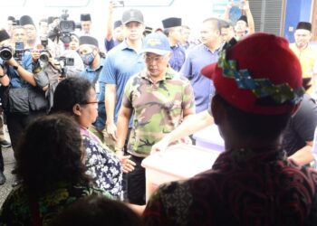 AL-SULTAN Abdullah Ri’ayatuddin Al-Mustafa Billah Shah (tengah) berkenan menyampaikan sumbangan banjir kepada mangsa di PPS SK Leban Chondong di Rompin, Pahang. -  UTUSAN/SHAIKH AHMAD RAZIF