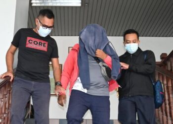 TERTUDUH (tengah) mengaku tidak bersalah di Mahkamah Sesyen, Ayer Keroh, Melaka atas pertuduhan menerima suapan berjumlah RM1,400 daripada sebuah syarikat pengangkutan. - UTUSAN/MUHAMMAD SHAHIZAM TAZALI