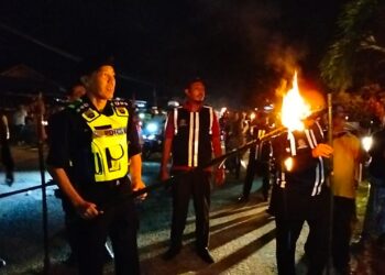 AMRAN Dolah (kiri) bersama anggota SRS dan KRT menggunakan karak semasa melakukan rondaan di Kampung Kok Pasir, Tumpat, Kelantan malam tadi.-UTUSAN/ROHANA ISMAIL.