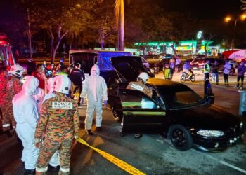 ANGGOTA bomba lengkap berpakaian PPE mengangkat mayat seorang lelaki yang ditemukan dalam sebuah kereta jenis Proton Wira di kawasan parkir di hadapan sebuah pasar raya di Seremban 2, Seremban hari ini.-UTUSAN/ZAKKINA WATI AHMAD TARMIZI