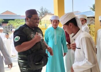 MOHAMAD RAZIS Zakaria (kiri) ketika menghantar sumbangan di sebuah maahad tahfiz di Thailand baru-baru ini.