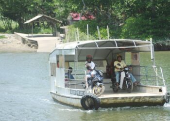 PENDUDUK menaiki bot penambang bagi menyeberang Sungai Sepang dari Bukit Pelandok di Port Dickson ke Sungai Pelek, Sepang, Selangor. – UTUSAN/MOHD. SHAHJEHAN MAAMIN