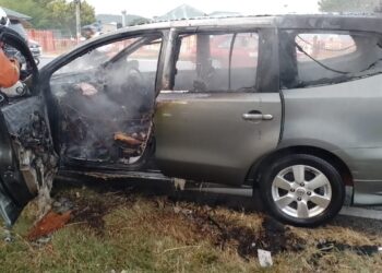 ANGGOTA bomba memadamkan kebakaran sebuah kereta yang dinaiki lima sekeluarga yang dalam perjalanan ke sekolah dalam kejadian di Chembong, Rembau hari ini.-GAMBAR/IHSAN BOMBA.