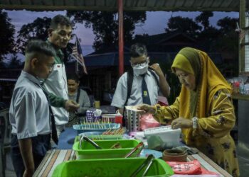 GELAGAT para pelajar membeli sarapan di gerai berhampiran SK Krubong, Melaka. - UTUSAN/SYAFEEQ AHMAD