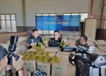 AZMAN Ismail (tengah) menunjukan minyak masak paket yang dirampas semasa sidang media stor KPDN Kelantan di Pengkalan Chepa, Kelantan hari ini.- UTUSAN/ROSLIZA MOHAMED