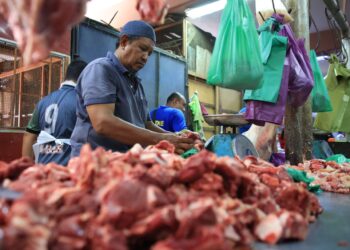 SEORANG peniaga sibuk memotong daging untuk pelanggan di Pasar Siti Khadijah Kota Bharu, Kelantan.-UTUSAN/KAMARUL BISMI KAMARUZAMAN.