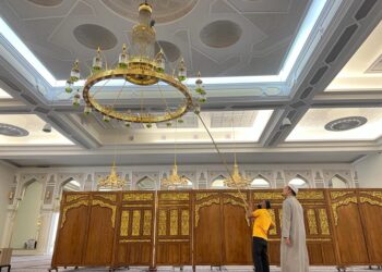 MUHAMAD Khirul Safarudin Zulkifli (kanan) melihat pekerja melakukan pembersihan lampu di Masjid Razaleigh, Bandar Lama, Gua Musang, Kelantan.UTUSAN/AIMUNI TUAN LAH