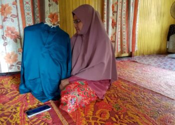 WAN Rubiah Wan Abdullah menunjukkan baju Melayu yang dibeli untuk arwahnya bagi menyambut Aidilfitri tahun lalu di rumahnya di Kampung Penambang, Kota Bharu, Kelantan-UTUSAN/ROHANA MOHD.NAWI.