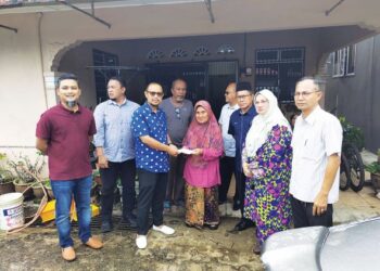 HARIS SALLEH Hamzah (tiga dari kiri) menyampaikan sumbangan kepada Kamariah Abd. Samad (tengah) di Taman Rumah Kos Rendah peringkat 3 di Jerantut, Pahang. – UTUSAN/SALEHUDIN MAT RASAD