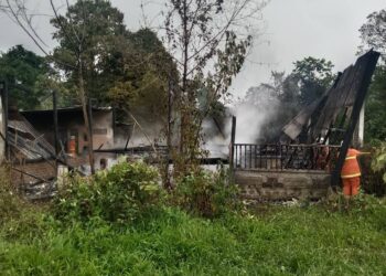 ANGGOTA Bomba Balai Bomba dan Penyelamat Pasir Mas berusaha memadam kebakaran rumah di Kampung Bechah Menerong, Pasir Mas Kelantan pagi tadi.-UTUSAN/IHSAN BOMBA