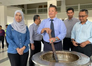RAZLI Che Razak (tengah) bersama Mastura (kiri) meninjau penyediaan bubur lambuk untuk diagihkan kepada warga UMK Kampus Bachok, Kelantan hari ini. UTUSAN/TOREK SULONG