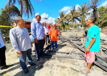 MOHD. Yaki Mohamed Zain (kanan) sugul semasa menceritakan kejadian kebakaran rumahnya kepada Mohd. Huzaimy Che Husin (dua kiri) di Kampung Perupuk, Bachok, kelantan hari ini. UTUSAN/TOREK SULONG