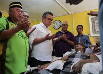 ADLY Zahari (tengah) melawat Masrizal Ishak yang terlantar kerana menghidap penyakit Systemic Lupus Erythematosus (SLE) ketika PPV peringkat Negeri Kedah di Hutan Kampung, Alor Setar. -UTUSAN/SHAHIR NOORDIN