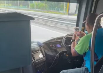 TANGKAP layar video pemandu bas memandu sambil menggunakan telefon tular di media sosial.