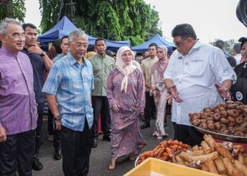 AB. RAUF Yusoh (kanan) menunjukkan juadah ikonik Melaka, kuih keria kepada Yang di-Pertuan Agong, Al-Sultan Abdullah Ri'ayatuddin Al-Mustafa Billah Shah (dua dari kiri) dan Raja Permaisuri Agong, Tunku Azizah Aminah Maimunah Iskandariah (dua dari kanan) di Bazar Ramadan Peringgit, Melaka. - UTUSAN/SYAFEEQ AHMAD