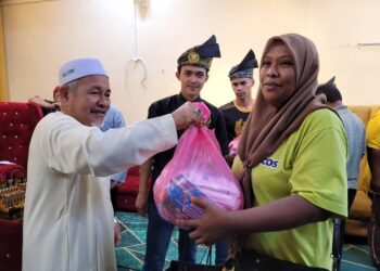 TUAN Ibrahim Tuan Man (tengah) diringi Wan Mohd. Raimiey Syazerin (dua dari kiri) semasa menyampaikan sumbangan kepada 100 asnaf di Kampung Lepar Limbat, Kota Bharu, Kelantan semalam. UTUSAN/MUSTAQIM MOHAMED.