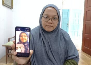 NOOR FATIMAHTUL ZAHARAH Talib menunjukkan wajah anaknya Aliah Qistina Budiyanto yang hilang pada di Taman Maju, Jasin, Melaka.