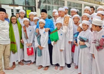 AHMAD Zahid Hamidi (depan tiga kanan) dan Mohd. Arifin Mohd. Arif (empat kiri) bersama anak-anak tahfiz dalam Majlis Santunan Kasih Ramadan di Masjid Kampung Benoni, Papar.