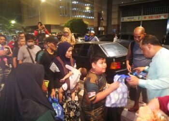 SULAIMAN Sa'mian (kanan) menyampaikan sumbangan kepada anak-anak gelandangan di sekitar Kuala Lumpur.