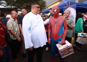 AB. RAUF Yusoh (kiri) beramah mesra bersama pengunjung Bazar Ramadan Rahmah di Masjid Tanah, Melaka.