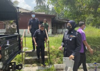 ANGGOTA polis selesai memeriksa keadaan rumah didiami Zulkarnain yang ditemukan meninggal dunia di ruang tamu di Kampung Masjid Selemak, Rembau pagi tadi.-UTUSAN/NOR AINNA HAMZAH.