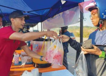 AINON Mohamad Ikmal Abd. Ghani (kiri) menjual air balang buah-buahan dengan harga RM1 di Bandar Utama, Gua Musang, Kelantan. 
– UTUSAN/AIMUNI TUAN LAH