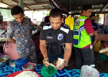 PEGAWAI Penguatkuasa MPKB-BRI menunjukkan nasi yang siap dibungkus dalam serbuan di sebuah premis di Kampung Pangkalan Nangka, Pengkalan Chepa, Kota Bharu, Kelantan hari ini-UTUSAN/ROHANA MOHD.NAWI