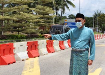 MOHD. Faizal Abdul Manap pada tahun lalu sewaktu menunjukkan penghadang jalan yang diletakkan sebagai langkah mengawal kesesakan di Jalan Seremban-Kuala Pilah sempena perayaan Aidilfitri yang akan disambut minggu hadapan.-UTUSAN/ZAKKINA WATI AHMAD TARMIZI.