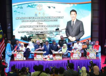 MOHAMAD Hasan membuka bungkusan sumbangan sempena gimik penyampaian sumbangan Aidilfitri di Auditorium Wisma Pertahanan. - MINDEF