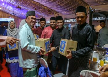 ANWAR Ibrahim menyampaikan sumbangan kepada penerima pada Majlis Penerapan Nilai-Nilai Murni dan Iftar Kementerian Dalam Negeri di SLAK, Sungai Petani. -UTUSAN/SHAHIR NOORDIN