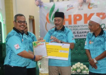 IZHAM Mustaffa (dua kanan) menyampaikan  replika cek Anugerah Kelab 30MT bernilai RM10,000 kepada pengurusan Felda Kota Gelanggi 3, peringkat 5 sempena Hari Produktiviti dan Kualiti Perladangan Wilayah Jengka di Felda Jengka Satu. - UTUSAN/SALEHUDIN MAT RASAD