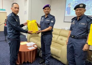 SAZALI Mohamad (tengah) menyampaikan penghargaan kepada salah seorang anggota JKDM di Tok Bali, Pasir Puteh, Kelantan, semalam. UTUSAN/TOREK SULONG
