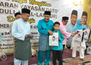 Ahmad Jazlan Yaakub (dua kiri) bersama Pengerusi Yayasan Datuk Che Abdullah Al-Lambori, Datuk Che Abdullah Mat Nawi menyampaikan wang zakat kepada penerima anak yatim dan asnaf di Tumpat, Kelantan semalam-UTUSAN/ROHANA ISMAIL