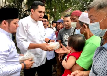 DR. Muhammad Akmal Saleh (dua kiri) mengagihkan makanan kepada asnaf di hadapan pekarangan Pejabat UMNO negeri di Kota Bharu, Kelantan semalam.-UTUSAN/ ROSLIZA MOHAMED